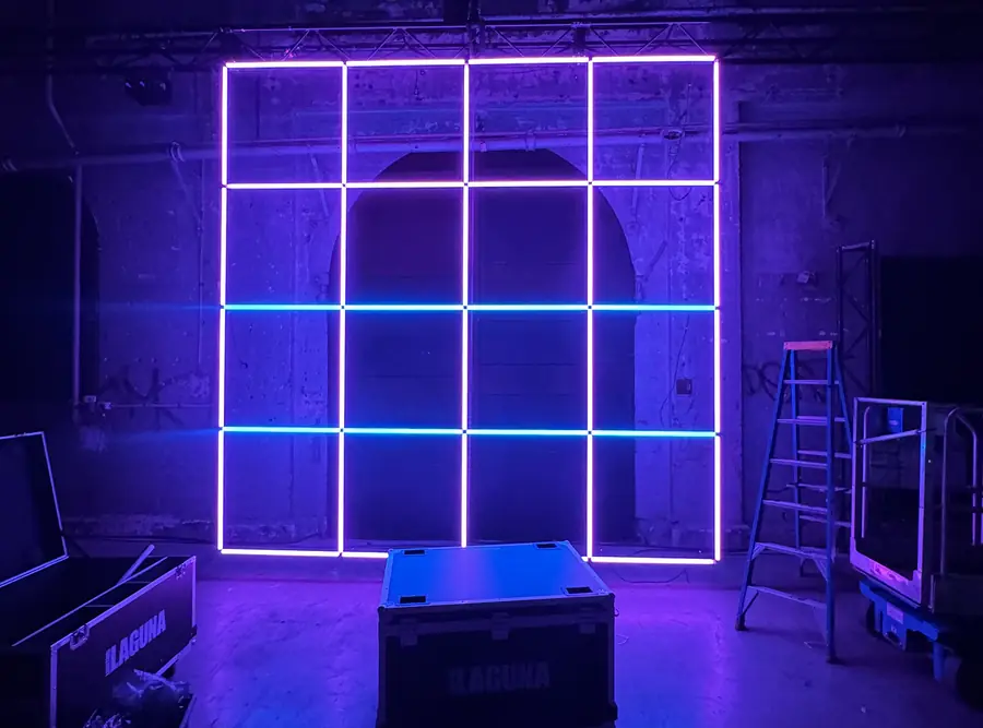 Glowing grid of LED tubes in a dark warehouse
